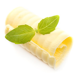 Curl of fresh butter with basil, isolated on white
