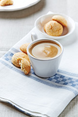 Cup of coffee with biscotti on a kitchen towel