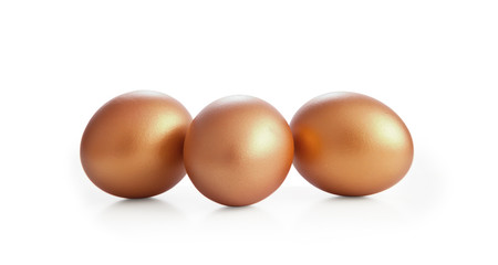 Golden eggs on white background.