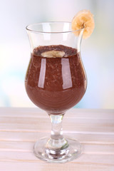 Cocktail with banana and chocolate on table on light background