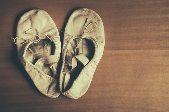 A Worn Out Pair Of Children's Ballet Shoes