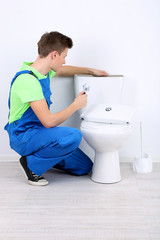Plumber with toilet plunger on light background