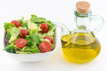 Fresh vegetable salad on plate and olive oil