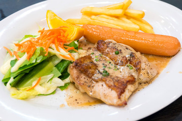 Chicken steak with sausage, salad, french fries and pepper sauce