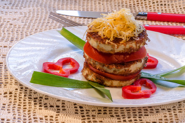 Fried zucchini with fresh tomato and grated cheese