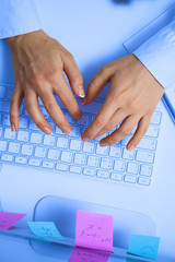 Female hands typing on white computer keyboard