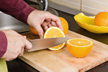 Closeup of man´s hands cutting oranges