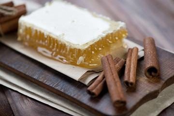 Cinnamon sticks and honeycomb on a wooden surface