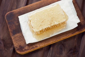 Above view of honeycomb, rustic wooden background