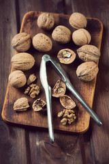 Vintage wooden cutting board with walnuts, high angle view