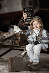 Obraz na płótnie Canvas Young Aviators in a homemade aircraft in a hangar with these pla