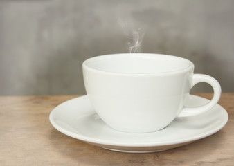 Cup of coffee on grunge wood table in vintage style,selective fo