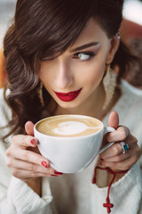 Young girl drinking coffee in a trendy cafe