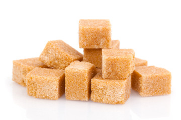 Brown cane sugar cubes on white background