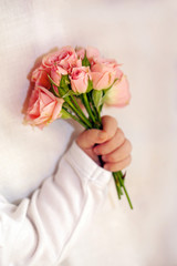 Close-up of newborn baby hand with flowers