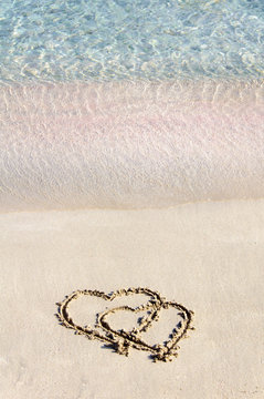 Two hearts drawn in the sand on a beautiful beach