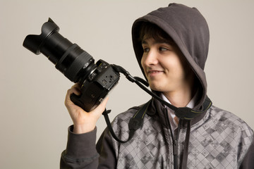 Portrait of cheerful young photographer with a professional came