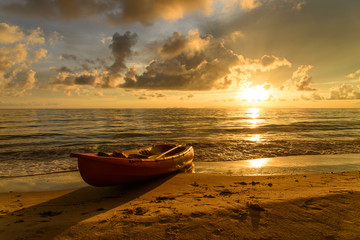 Obraz premium Onshore kayak boat with sunset in the background