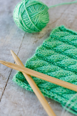 Knitting pattern and needles on a wooden background