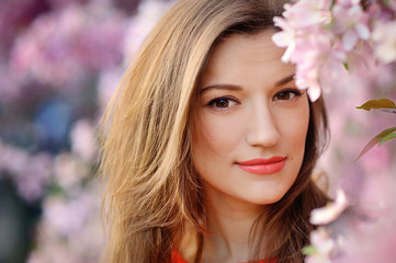 Naklejka premium Beautiful woman among spring blossom
