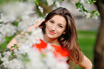 Naklejka premium Portrait of pretty girl near the blossomed tree