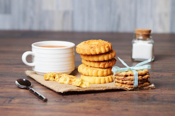A white cup and cookies on a table