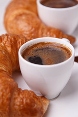Two cups of coffee and two croissants