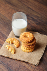 Delicious cookies on a sack cloth and a glass of milk