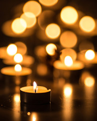 Single candle and many candles with bokeh effect