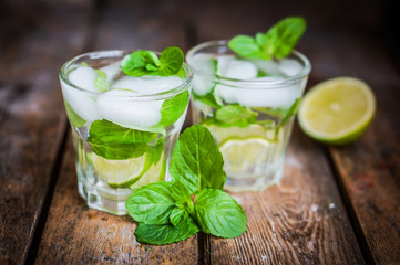 Water with lime,lemon and mint on rustic wooden table
