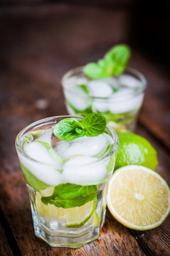 Water with lime,lemon and mint on rustic wooden table