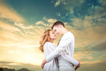 Couple embracing and watching one another under the sunny sky