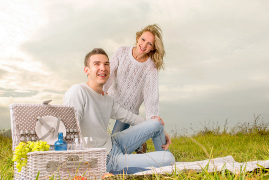 couple sitting on a picnic under the white sky