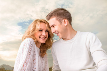 Naklejka premium Happy couple smiling under the sunny sky