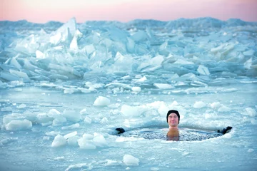 Fotobehang Wintersport Winterzwemmen. Man in een ijsgat