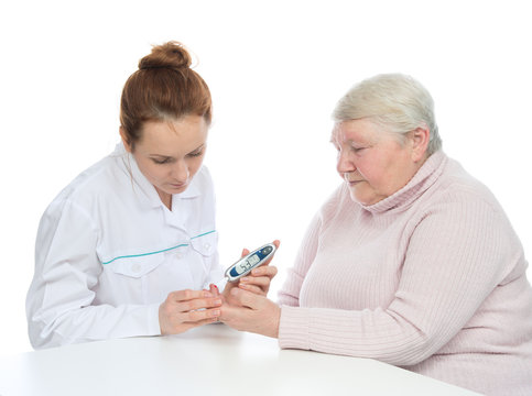 Doctor old woman measuring glucose level blood test