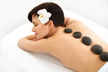 Obraz na płótnie Canvas Stone Massage. Beautiful Woman Getting Spa Hot Stones Massage 