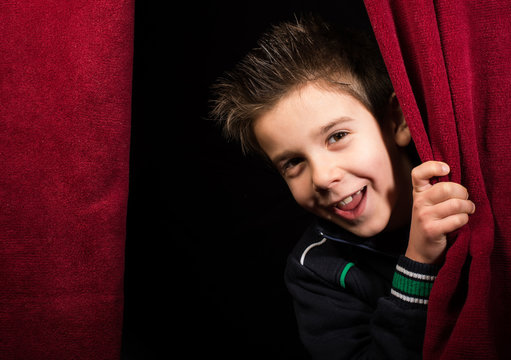 Child appearing beneath the curtain