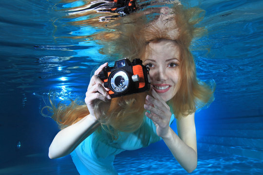 Woman underwater  with photo camera