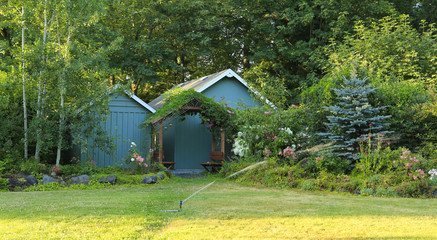 Flourishing farm backyard with sheds and garden house