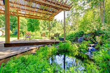 Picturesque backyard farm garden with small pond and patio area - obrazy, fototapety, plakaty
