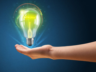 Glowing lightbulb in the hand of a woman