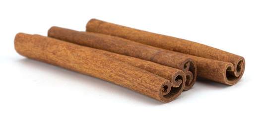 cinnamon sticks stacked on white background