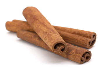cinnamon sticks stacked on white background
