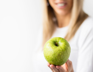 Healthy woman holding fresh green apple.