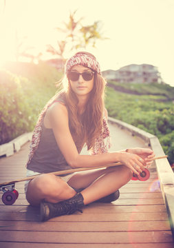 Beautiful young woman posing with a skateboard