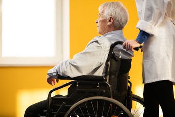 Fototapeta na wymiar Nurse woman with senior man in wheelchair r