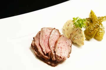 Slices of meat with marinated cucumbers