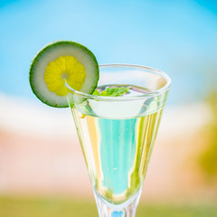 yellow cocktail with a slice of lime