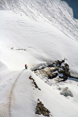 Fototapeta premium Skier climbing a snowy mountain